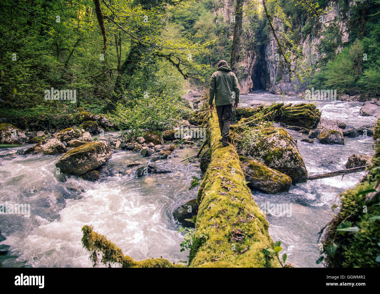 Hombre viajero cruzar el río sobre el estilo de vida al aire libre de registro concepto de supervivencia de viaje Foto de stock