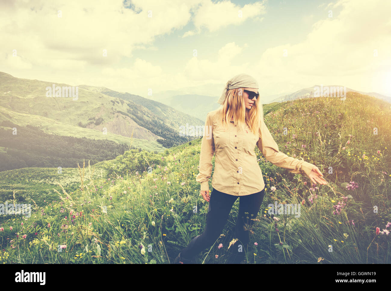 Mujer joven caminar concepto Lifestyle Viajes Vacaciones de verano al aire libre en las montañas antecedentes Foto de stock