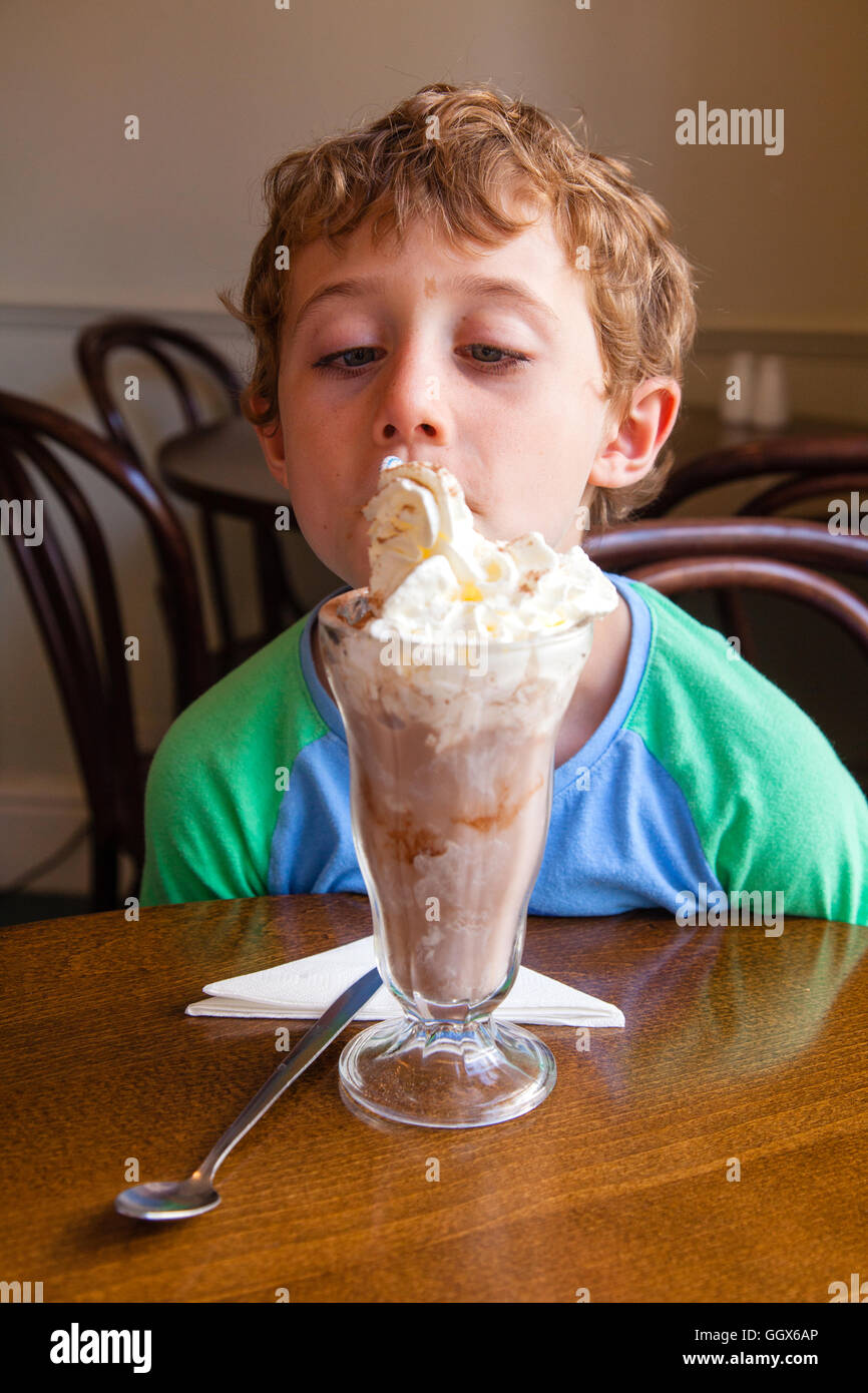 Los siete años de edad con un gran batido de chocolate, Totnes, Devon, Inglaterra, Reino Unido. Foto de stock
