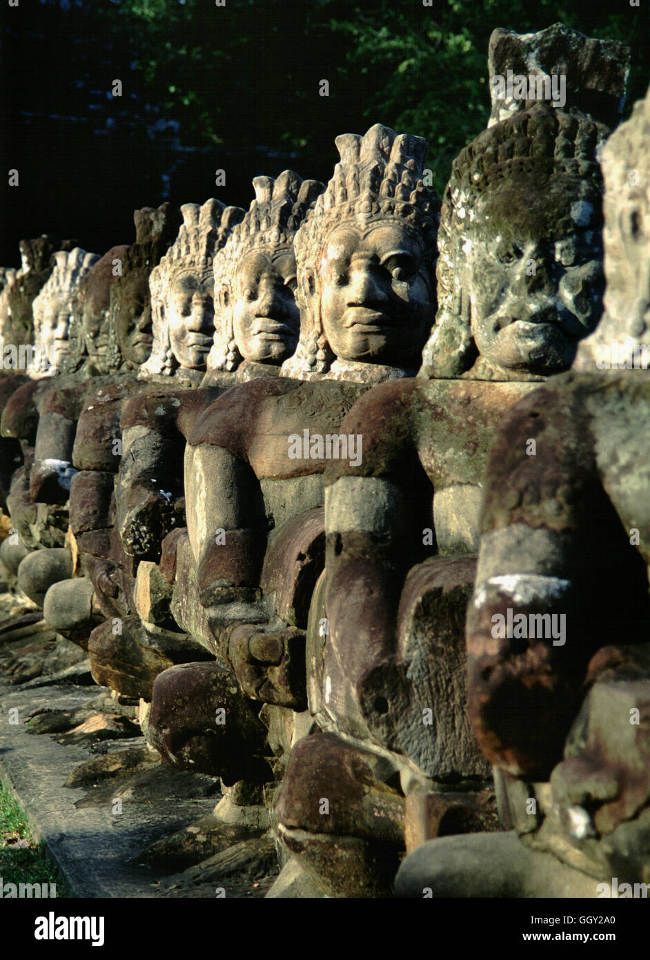 Cabezas de piedra gigante que recubre el boulevard aproximación a la puerta de Angkor Thom en Angkor Wat. Siem Reap, Camboya. Foto de stock