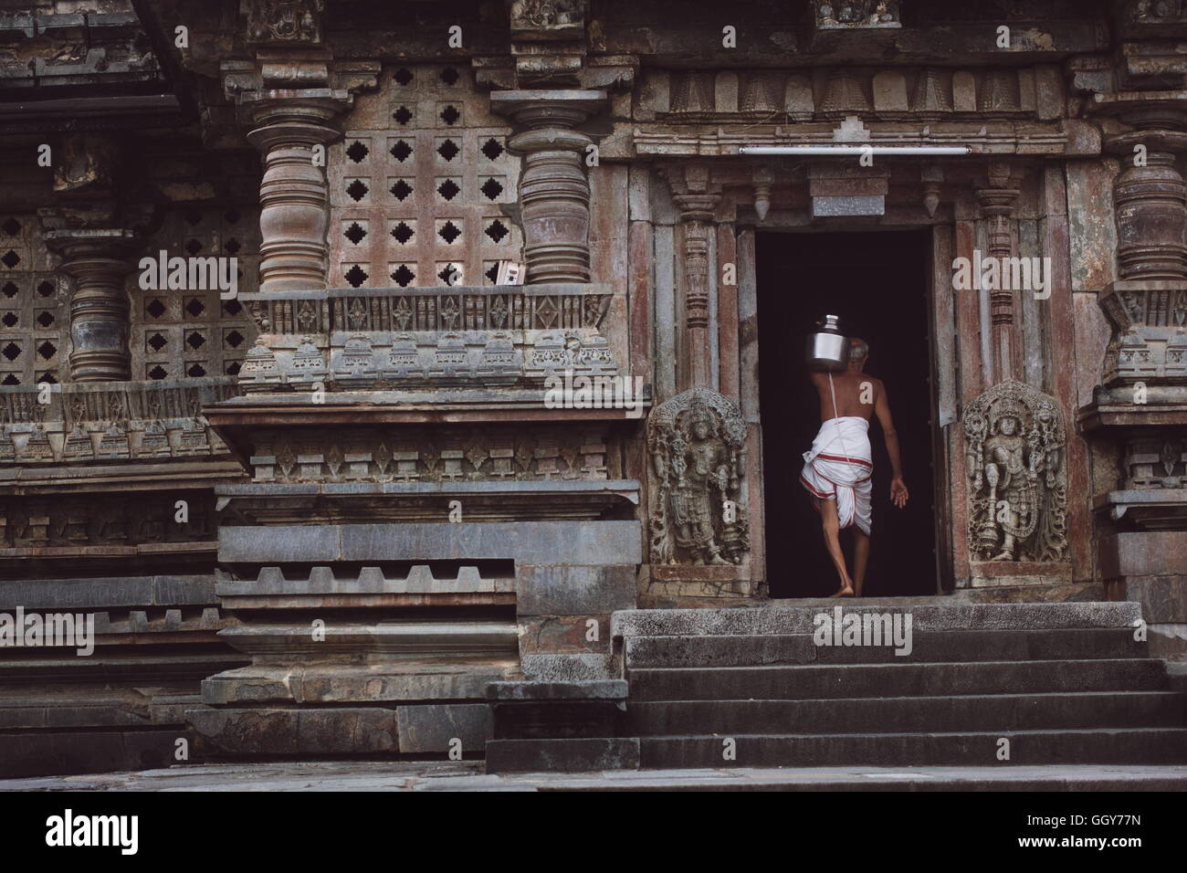 Sacerdote hindú llevando agua . Templo Chennakeshava.Belur. La India Foto de stock
