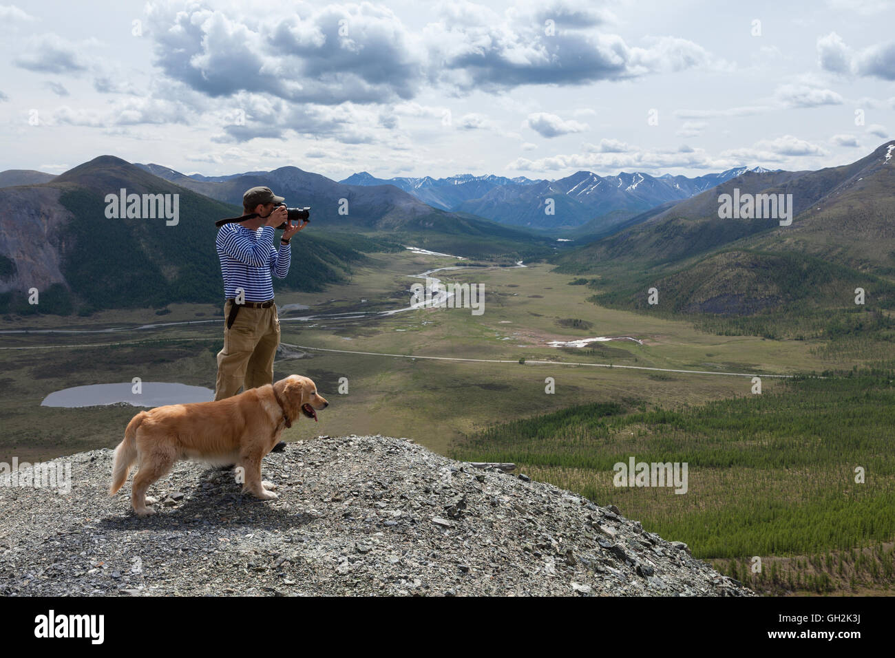 Fotografía hombre y su perro admirar el paisaje de montaña Foto de stock