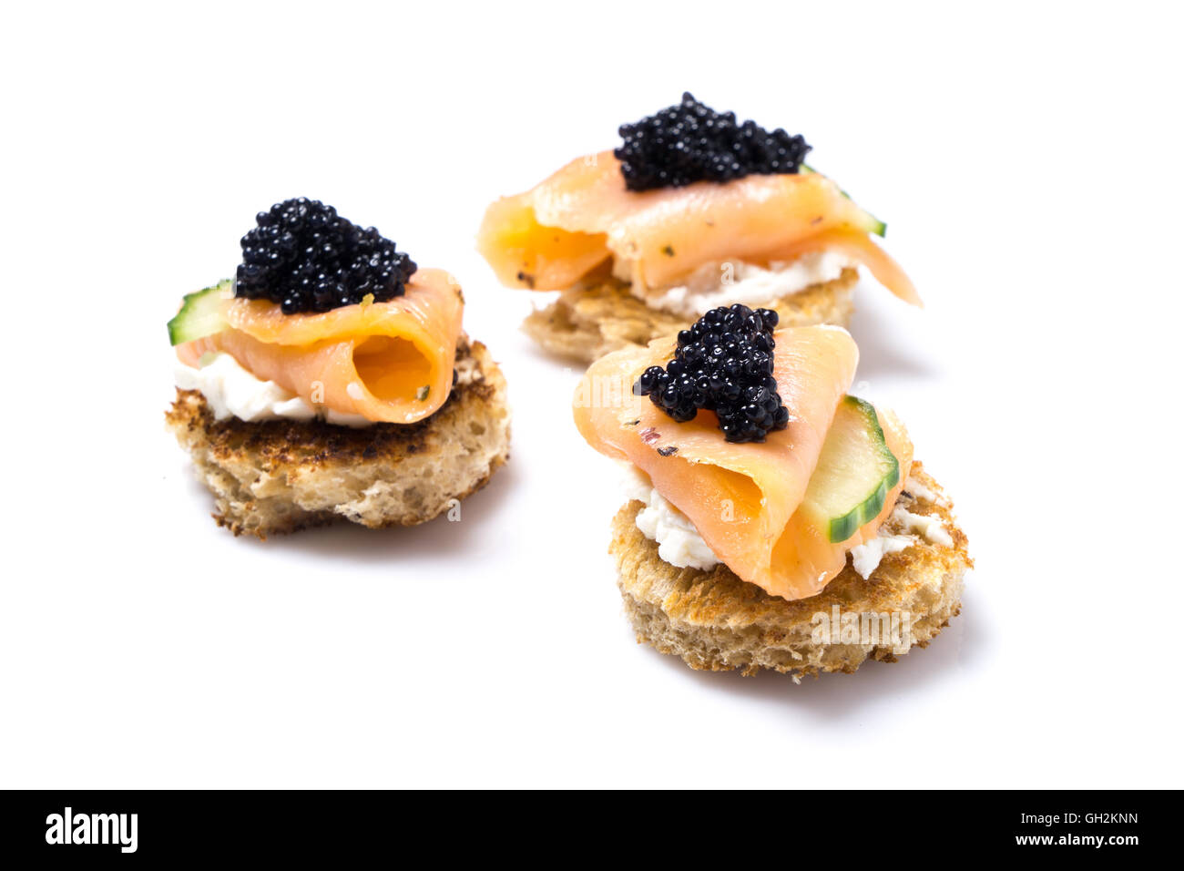 Aperitivo de salmón ahumado con queso crema y caviar aislado en blanco Foto de stock