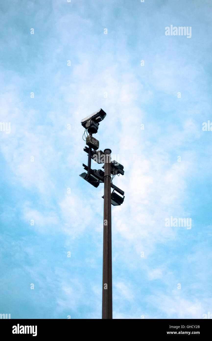 Una cámara de seguridad y luces de inundación en lo alto de un poste Foto de stock