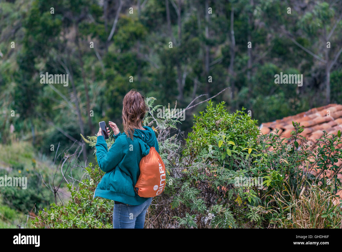 Vista posterior de la mujer joven mochilero en Ingapirca, un lugar turístico en el que se encuentra un antiguo templo inca ubicada en azul Foto de stock