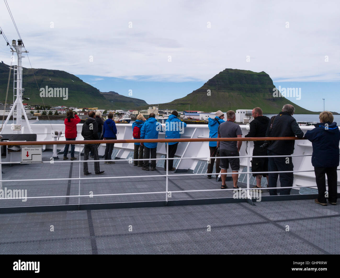 Los pasajeros en la proa del barco crucero viendo enfoque a pequeña comunidad pesquera de Grundarfjörður ciudad en la península de Snaefellsnes, Islandia y Kirkjufell Foto de stock