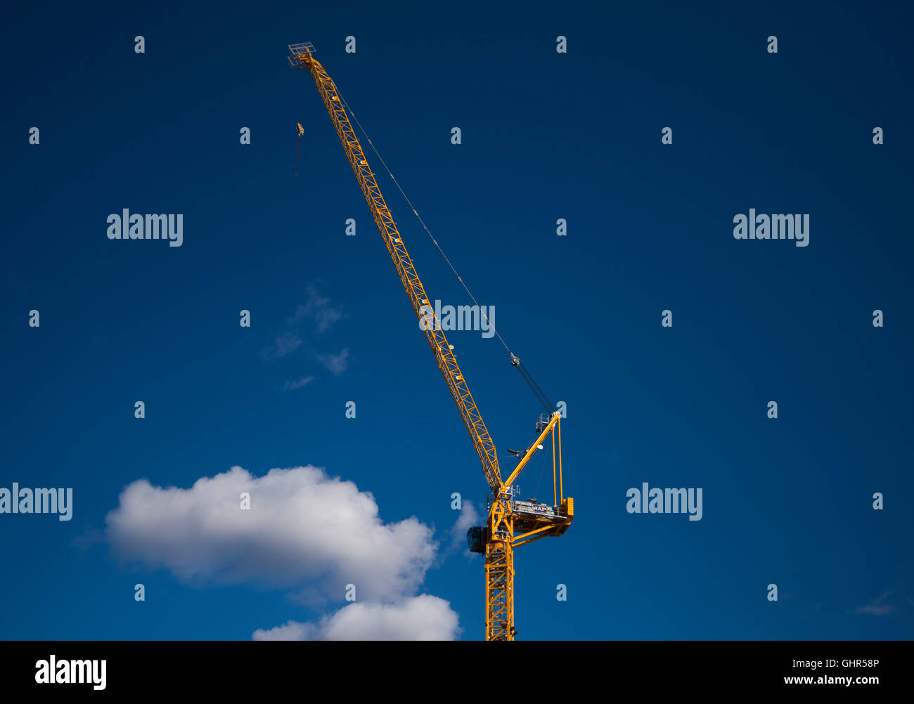 Grúas en un sitio de construcción de viviendas con un fondo de cielo azul. Foto de stock