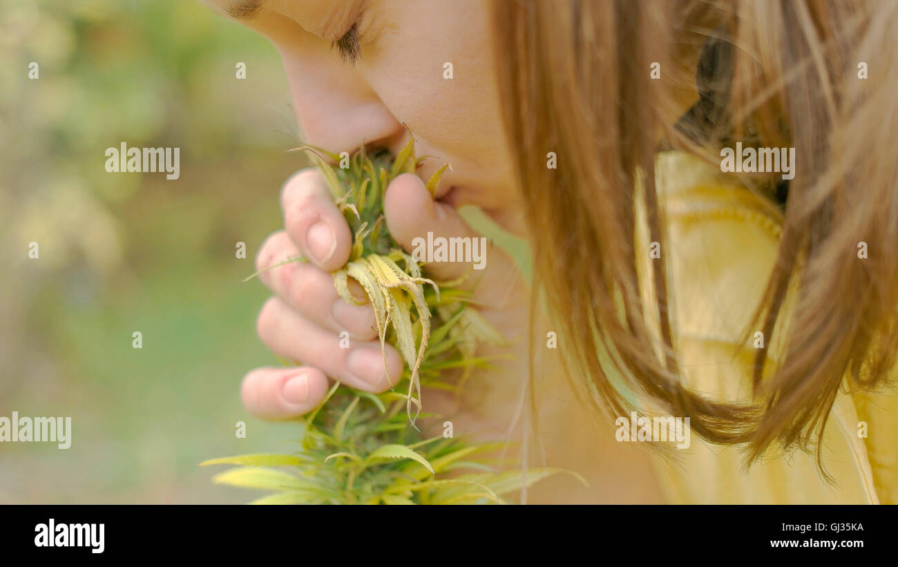 Joven mujer caucásica oliendo homegarden crecido planta Foto de stock