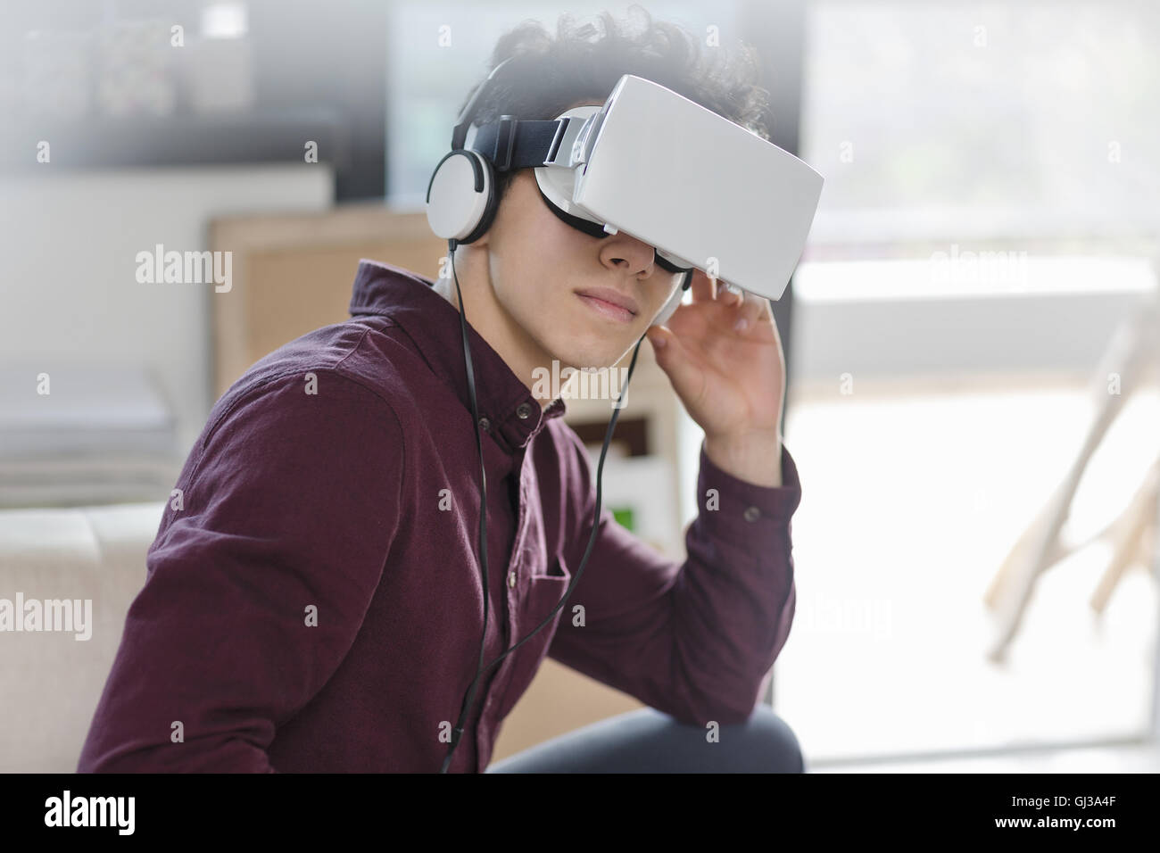 Joven hombre vestido con casco de realidad virtual Foto de stock