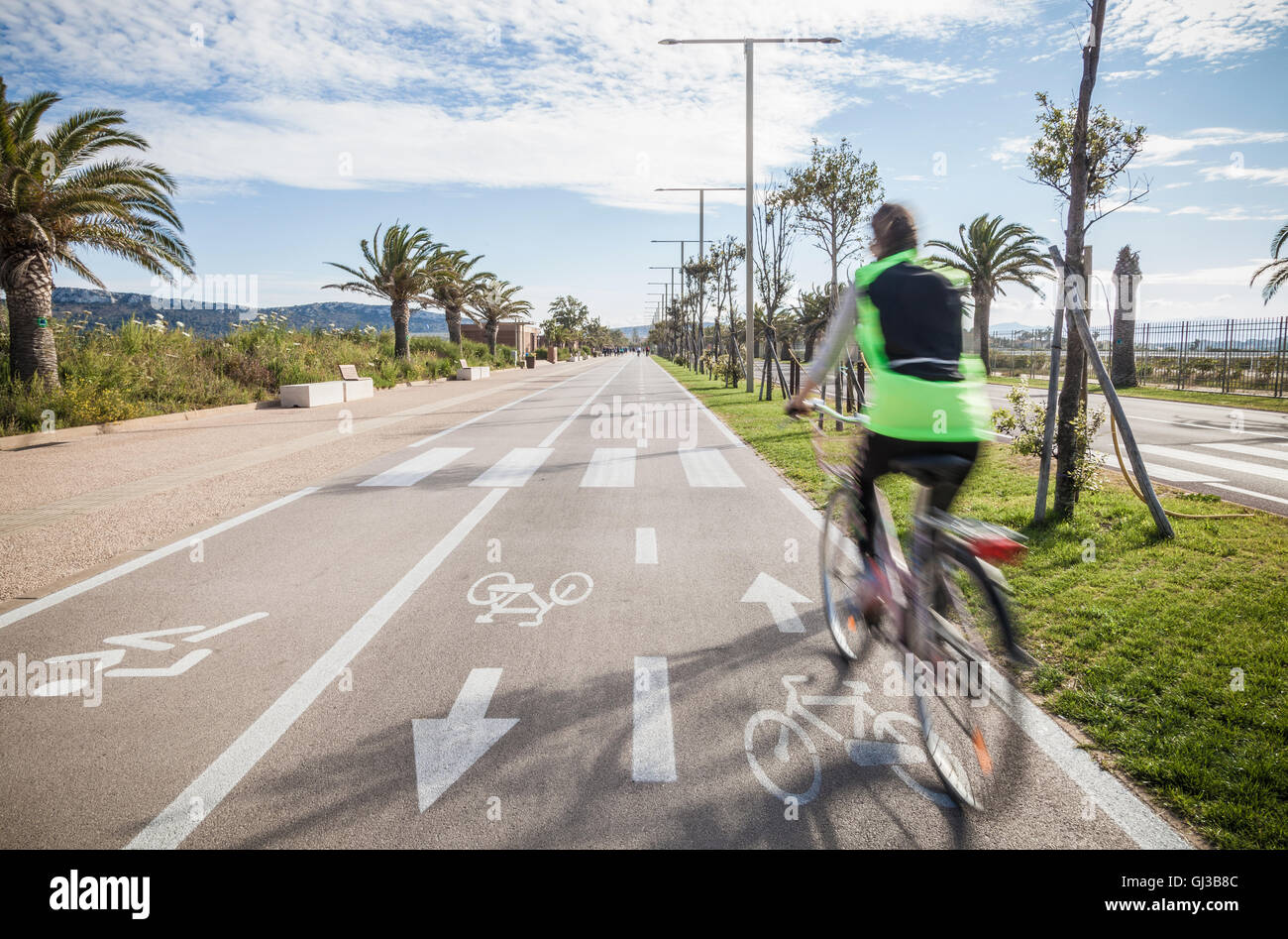 Vista trasera del ciclista alto desgaste vis chaqueta de ciclismo en el carril bici Foto de stock