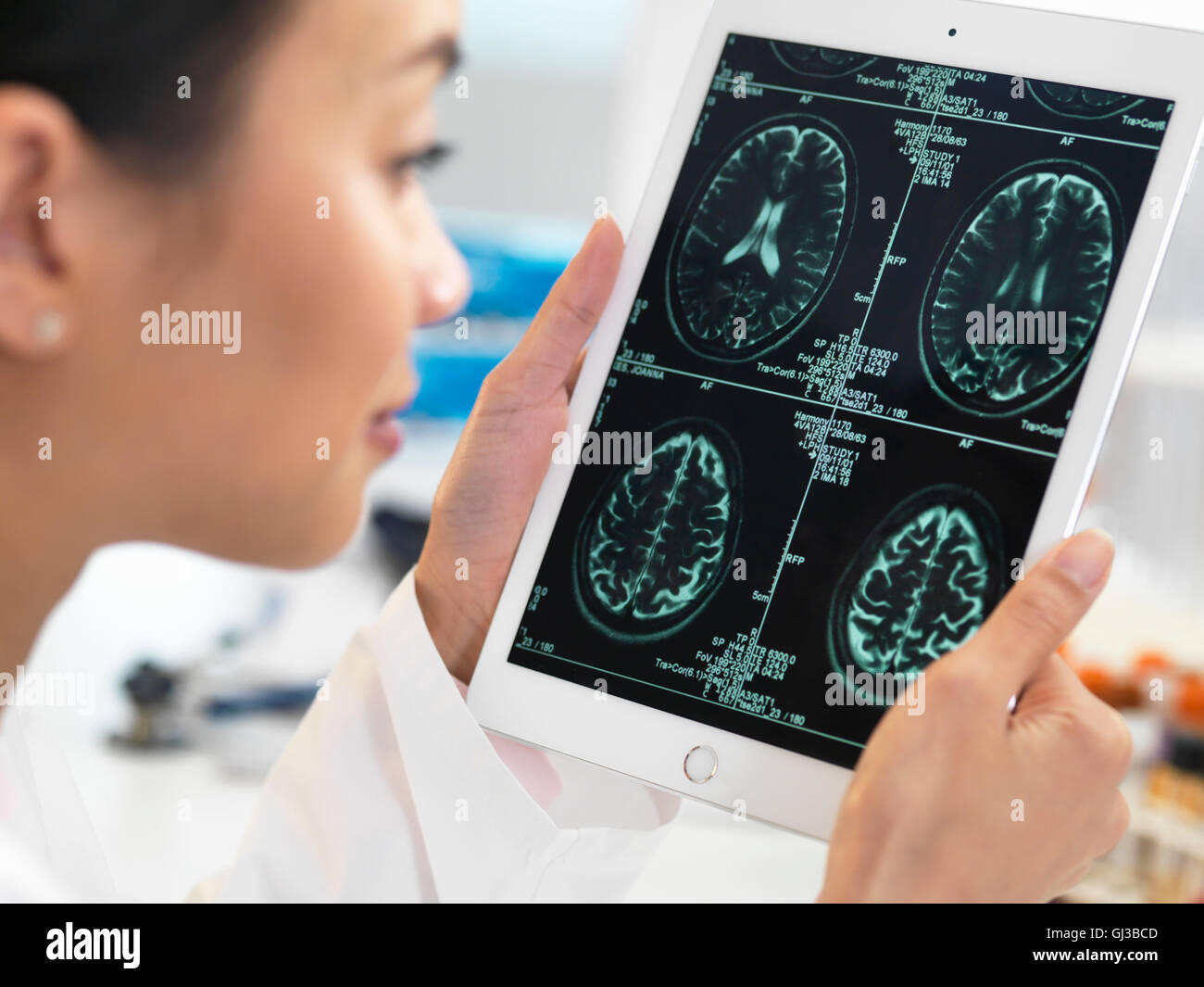 Doctor ver Tomografía computarizada del cerebro como resultado de tableta digital para detectar anormalidades Foto de stock