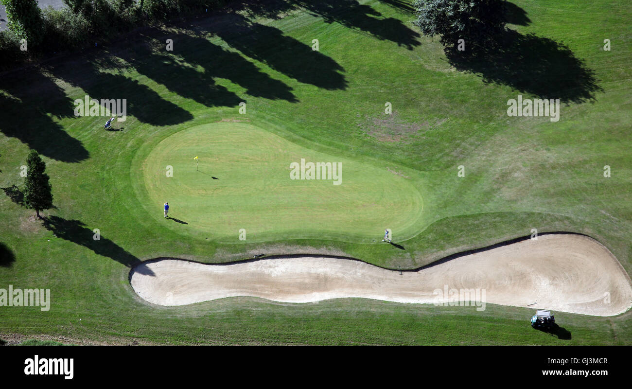 Vista aérea de los golfistas jugando un agujero en un green con bunker, Inglaterra, Reino Unido. Foto de stock