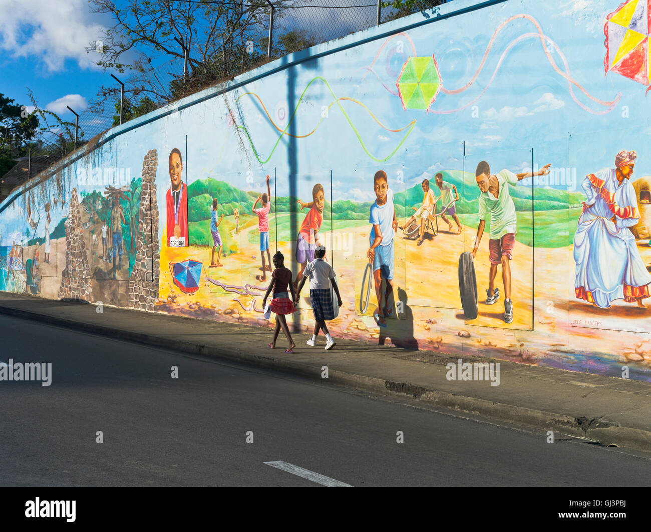 dh Scarborough street TOBAGO CARIBBEAN Dos niñas caminando por coloridos murales pintados de pared pintura mural arte pintura cultural pinturas trinidad Foto de stock