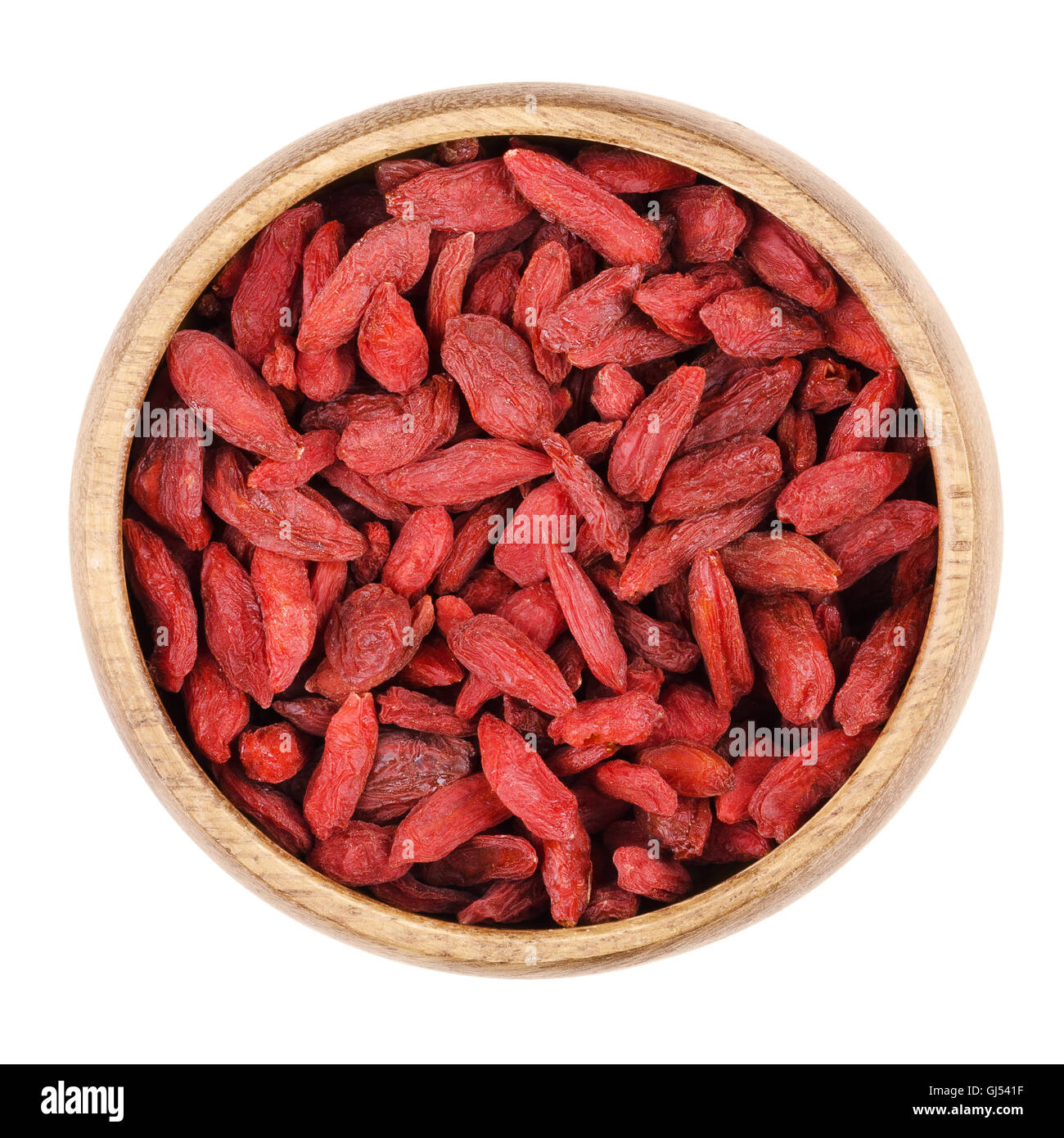 Goji Bayas en un recipiente sobre un fondo blanco, también llamado Bayas de Goji. Frutas rojas secas y semillas de Lycium barbarum. Foto de stock