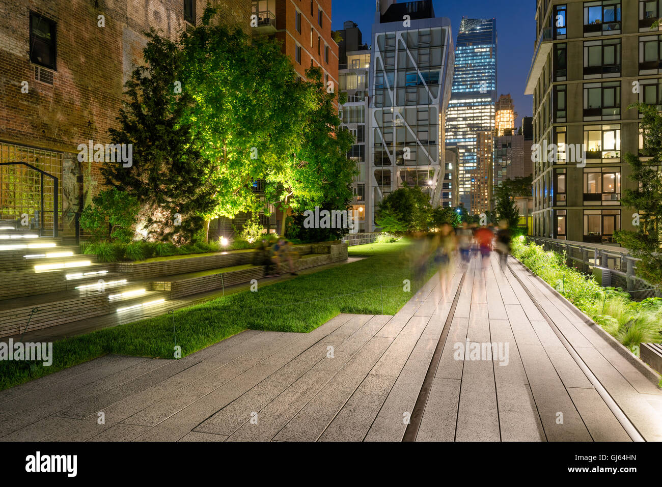 La Alta línea paseo iluminado en la penumbra rodeado de edificios antiguos y modernos en Chelsea, Manhattan, Ciudad de Nueva York Foto de stock