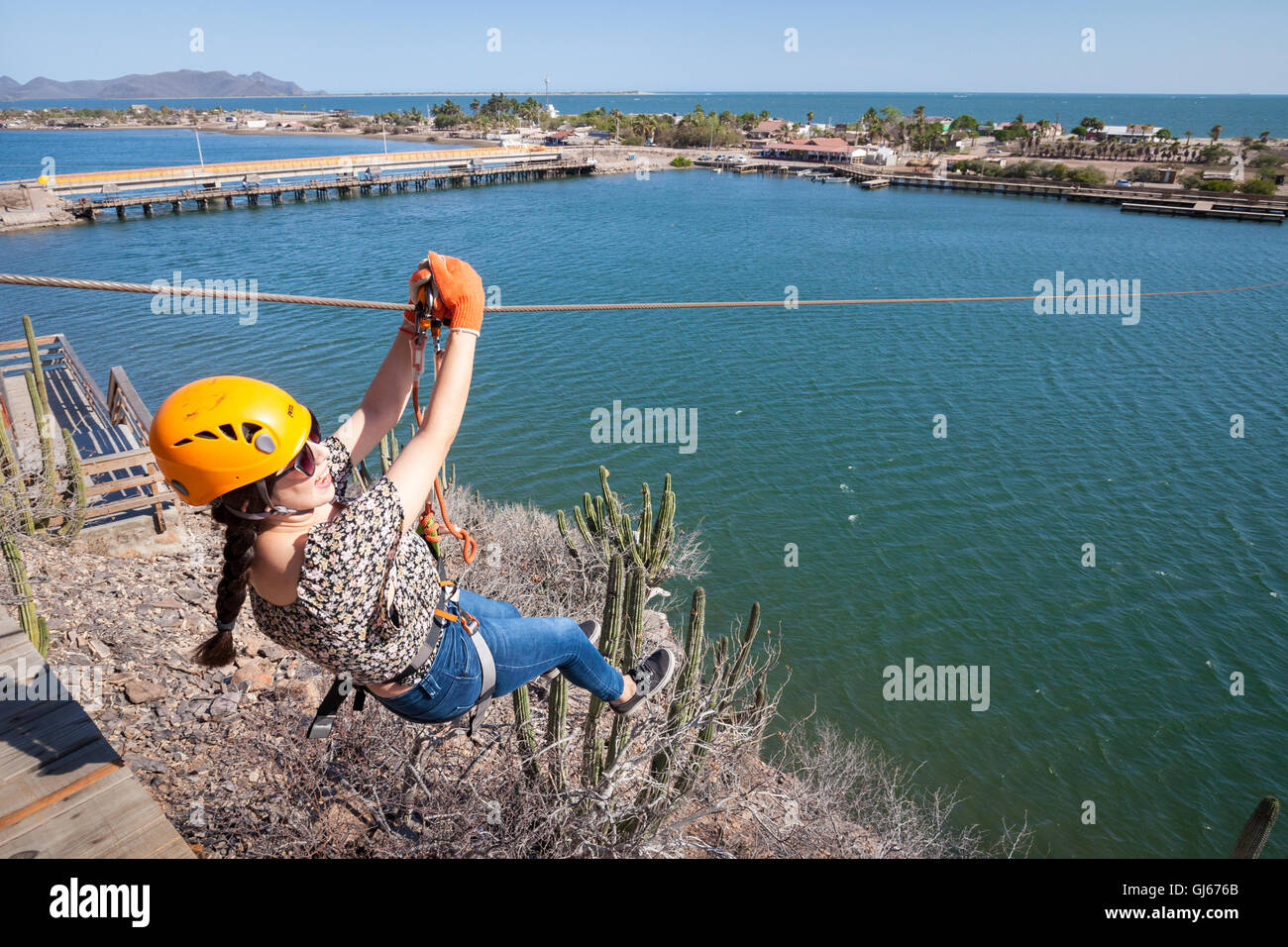 Un adolescente establece a través de una pequeña bahía de la tirolesa en Maviri playa cerca de Topolobampo, México. Foto de stock