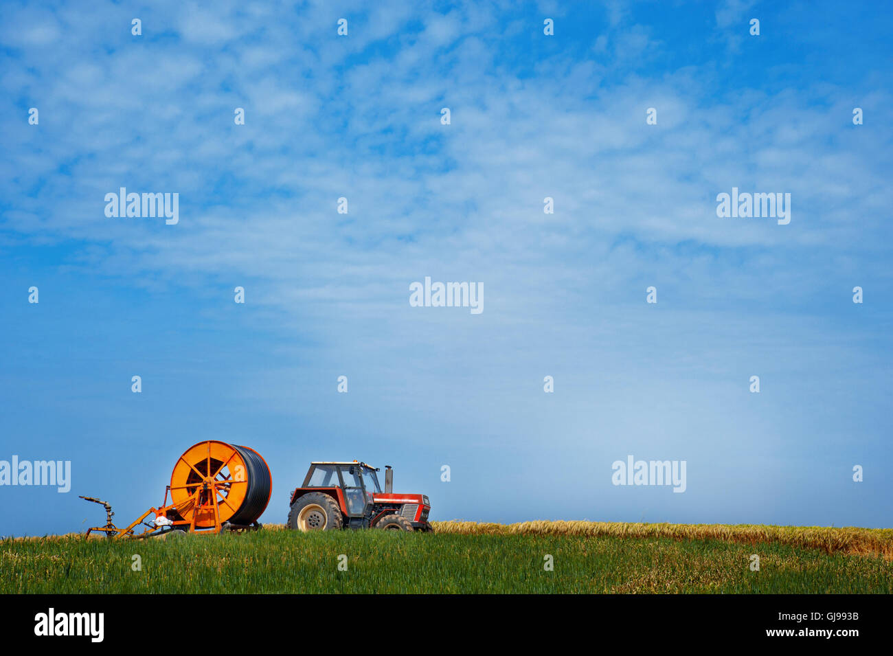 Tractor con sistema de riego en un campo en Tesalia, Grecia Foto de stock
