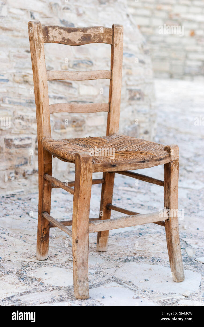 Antiguo de madera desvencijada silla de paja con adoquines de fondo como un  acercamiento Fotografía de stock - Alamy