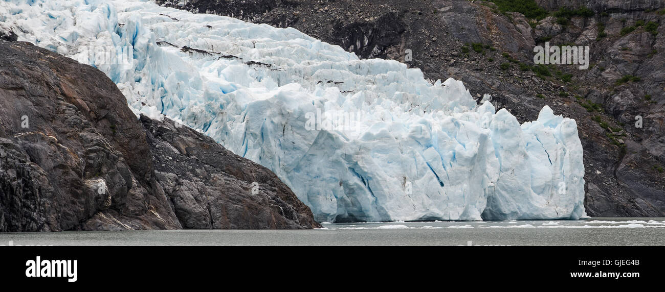 El blanco puro y el hielo azul fluye entre las paredes rocosas del lago Foto de stock