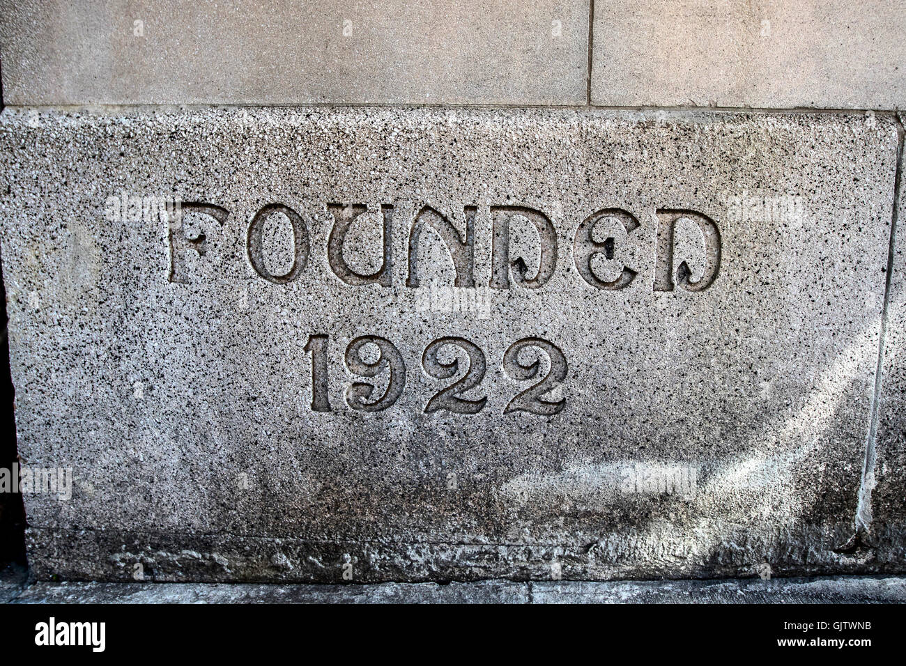 Palabras "Fundada en 1922" esculpido en una piedra de la pared de un edificio residencial. Foto de stock