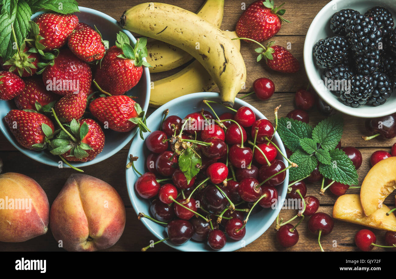 Verano variedad de frutos y bayas frescas sobre fondo de madera, vista superior, composición horizontal Foto de stock