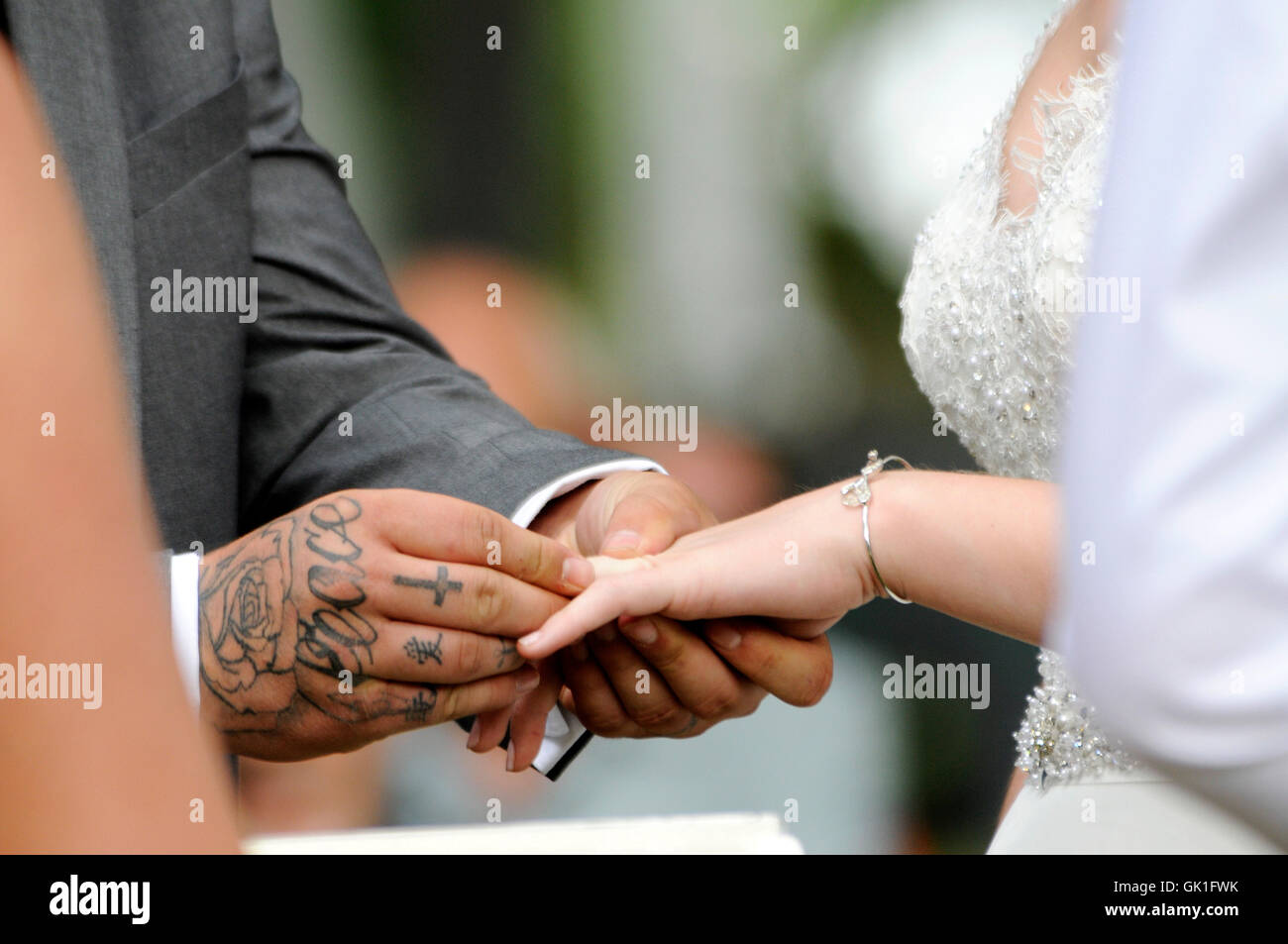 El novio coloca el anillo de boda de la mano de su esposa. Boda al aire libre. Foto de stock