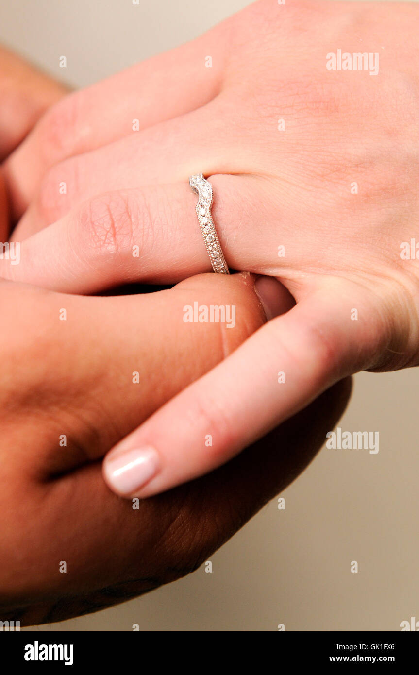 El novio coloca el anillo de boda de la mano de su esposa. Foto de stock