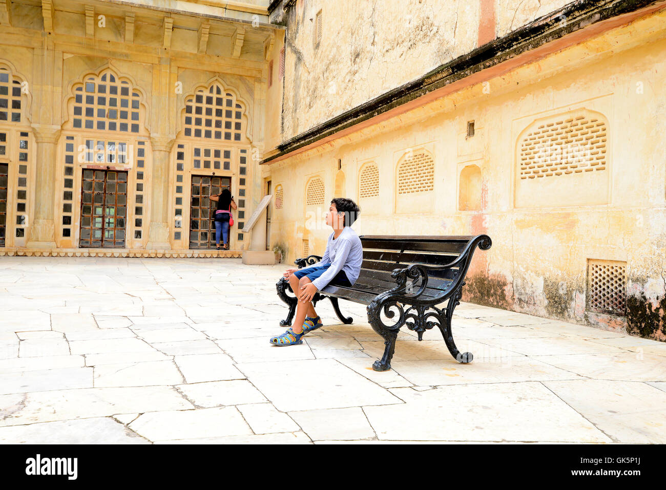 Un niño sentado solo en sillas de jardín en Fuerte Amber, Jaipur, Rajasthan, India. Foto de stock