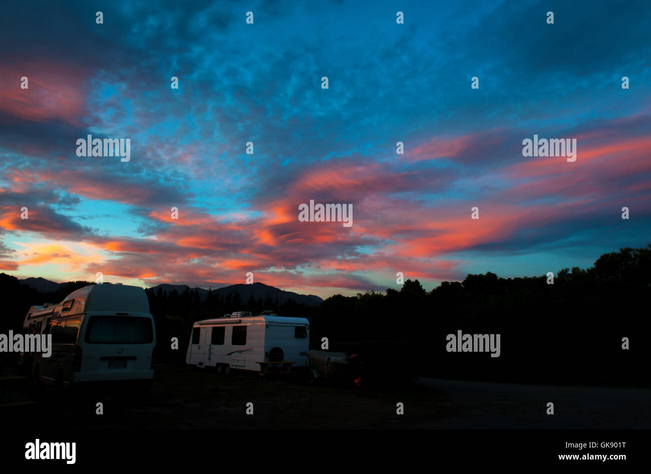 Campervans camping Peketa Beach, Kaikoura, Isla del Sur de Nueva Zelanda, durante la puesta de sol Foto de stock