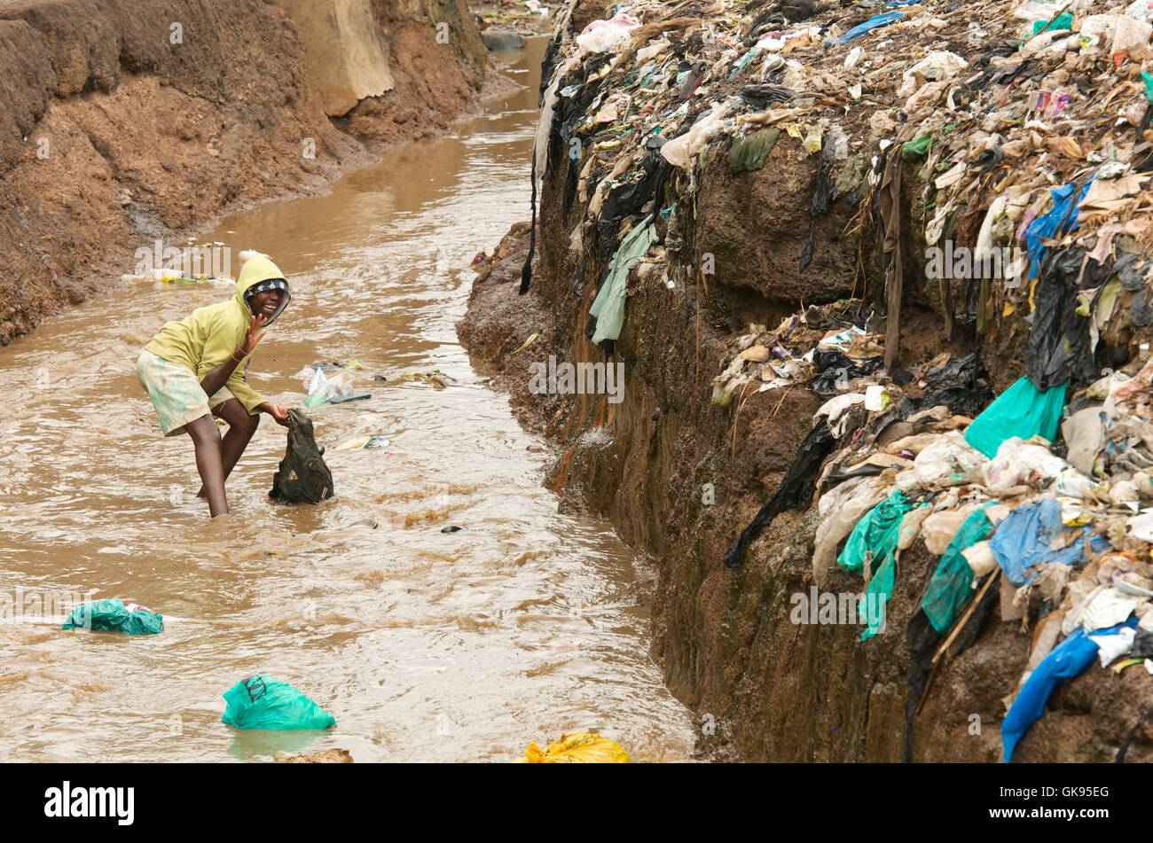 Niños jugando en el río sucio de Kibera en barrios de tugurios. Foto de stock