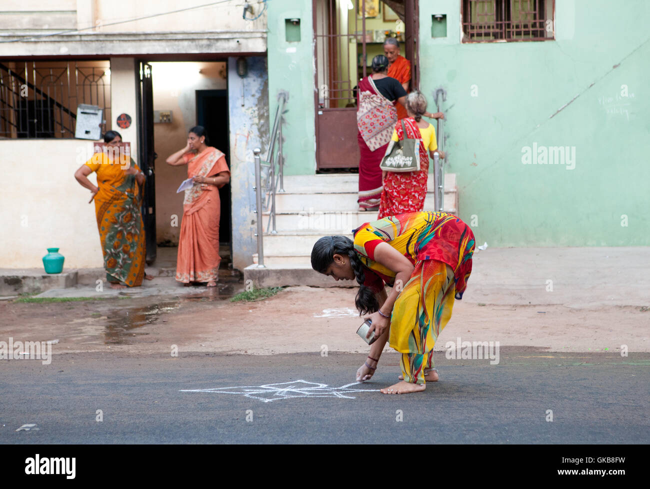 Mujer creación de harina de arroz ornamento en el asfalto para un festival religioso en Tiruchirappalli, India Foto de stock