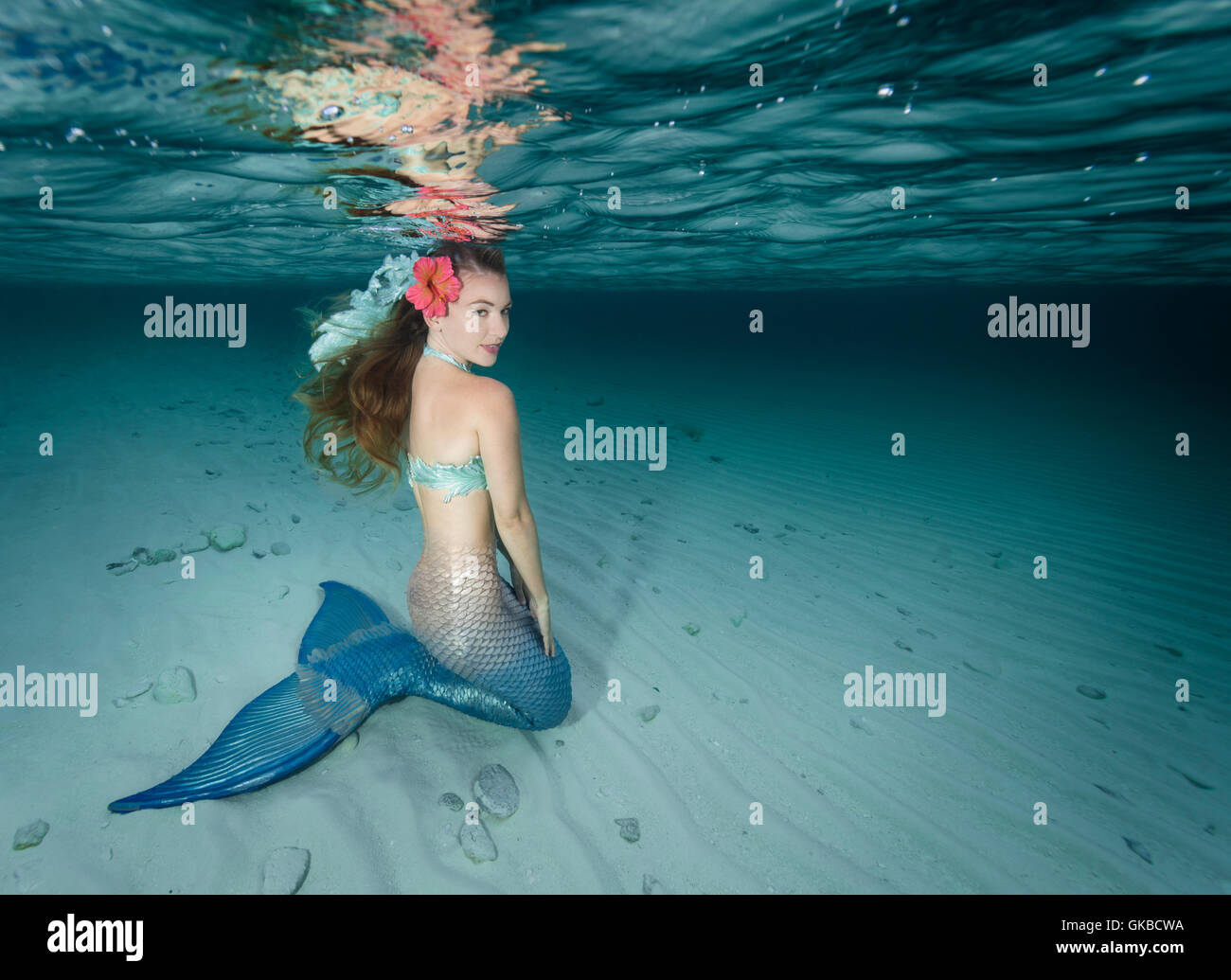 Joven morenita mermaid en las aguas someras de la costa de Highbourne Cay, Bahamas, Islas Cayos Exuma Foto de stock