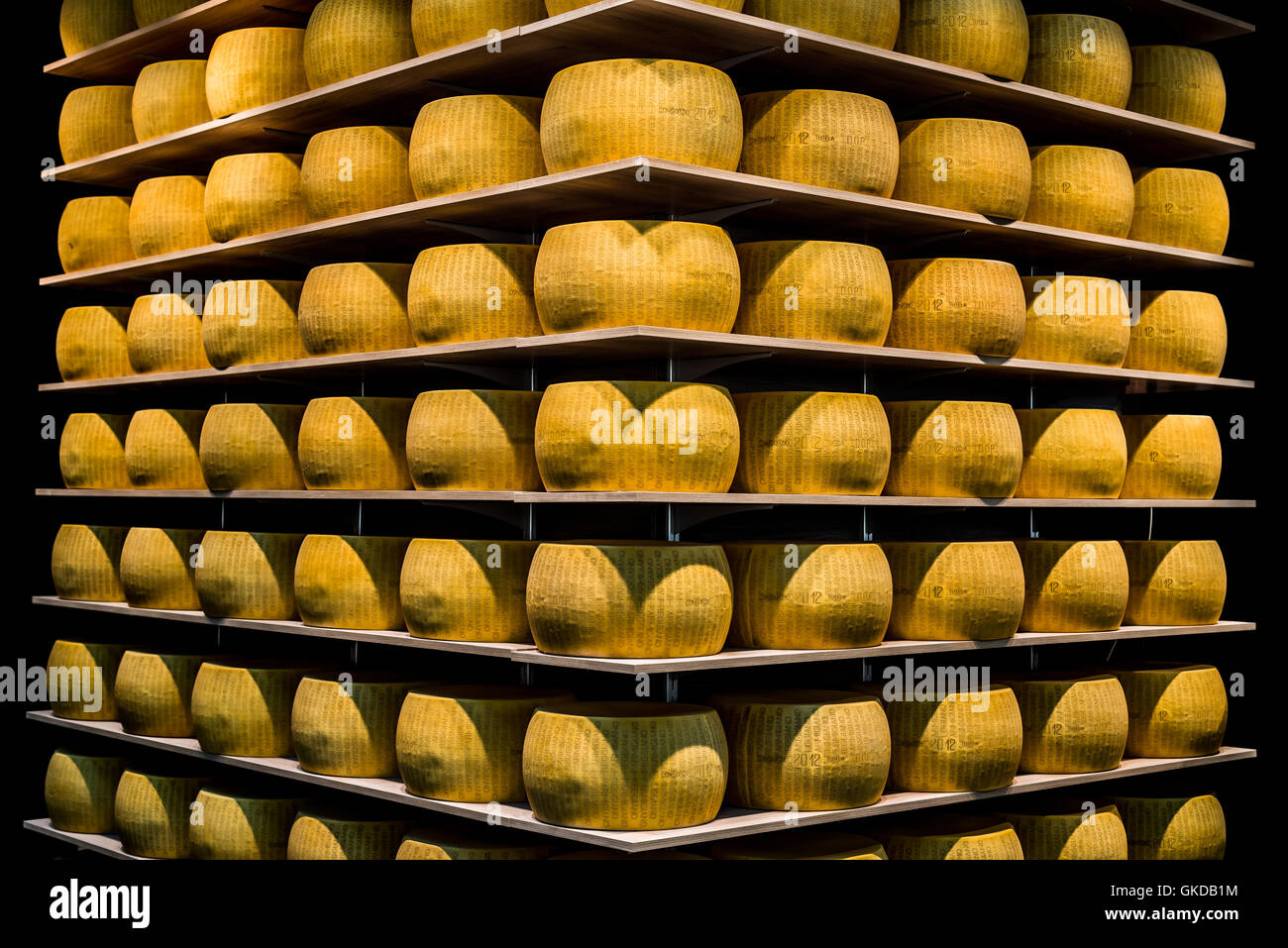 Las ruedas del Parmigiano-Reggiano queso parmesano o en las estanterías de un almacén de maduración en Parma. Foto de stock