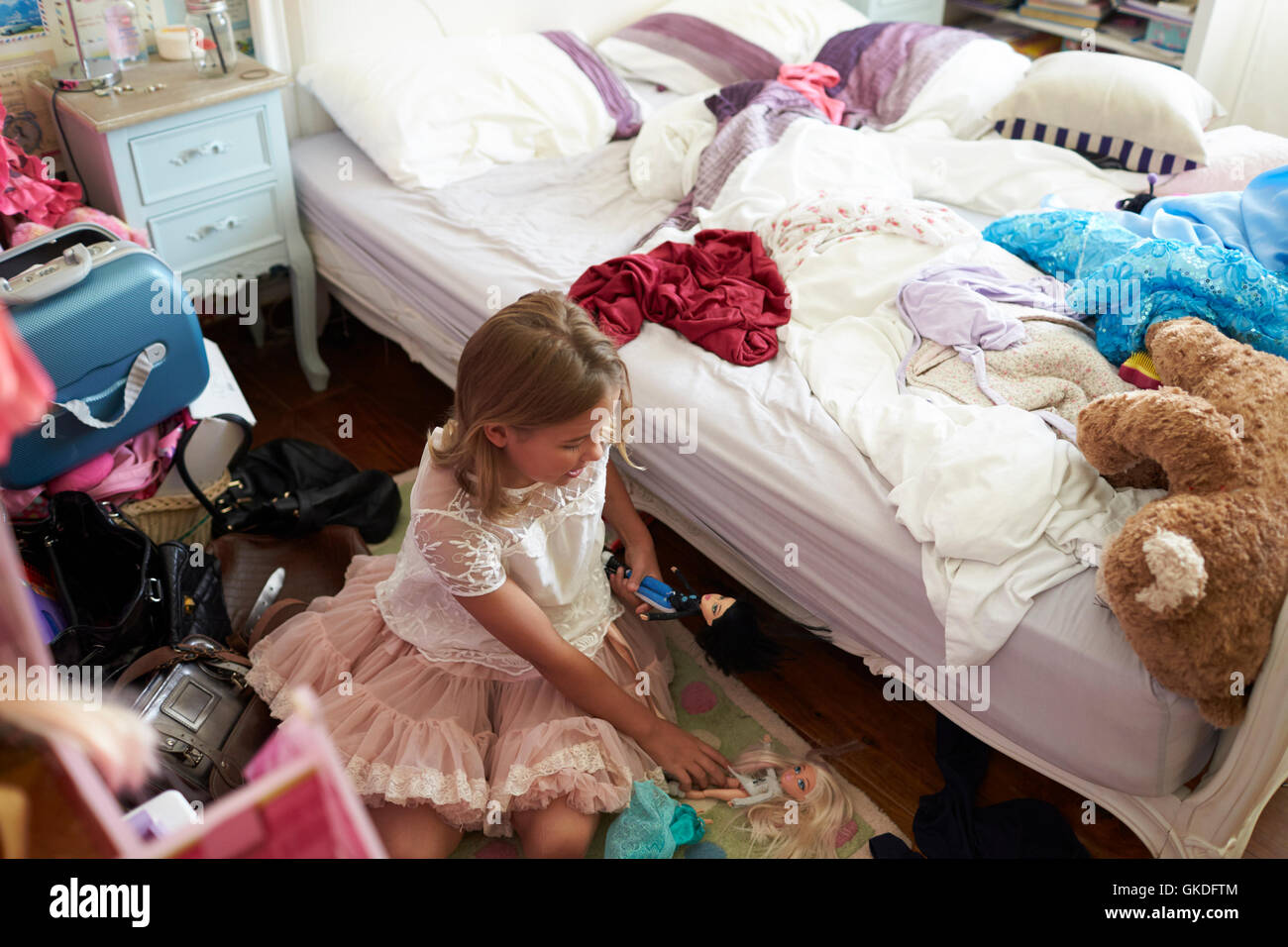Niña jugando en desordenado Dormitorio Foto de stock