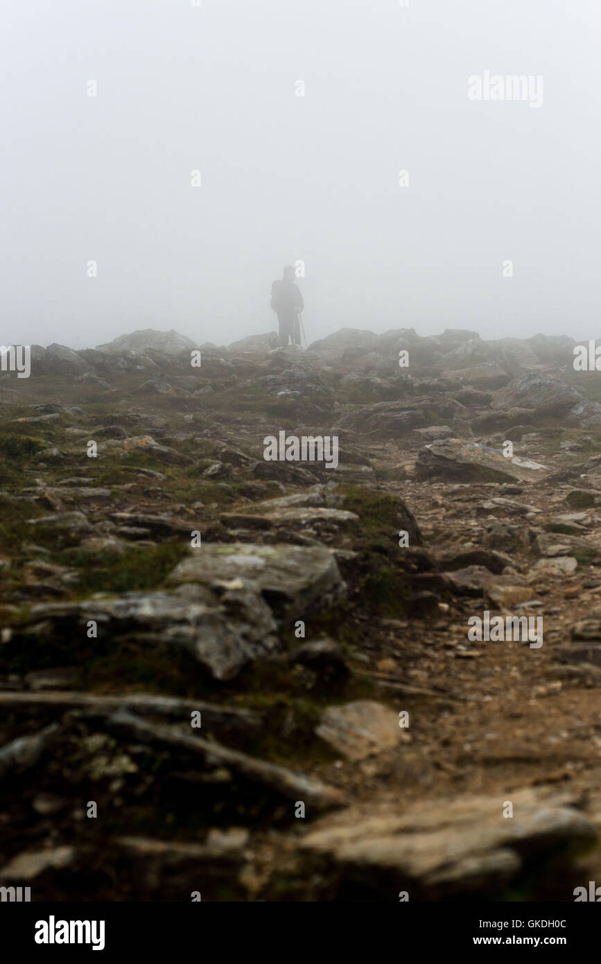 Hombre de pie en las nubes bajas con poca visibilidad en Ben Vorlich (loch ganan) Foto de stock