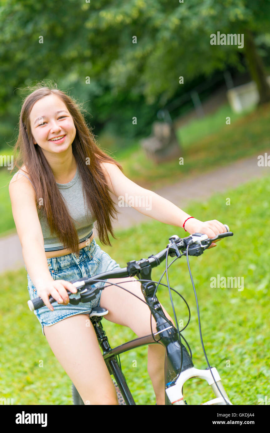 Jovencita correr en bicicleta Foto de stock