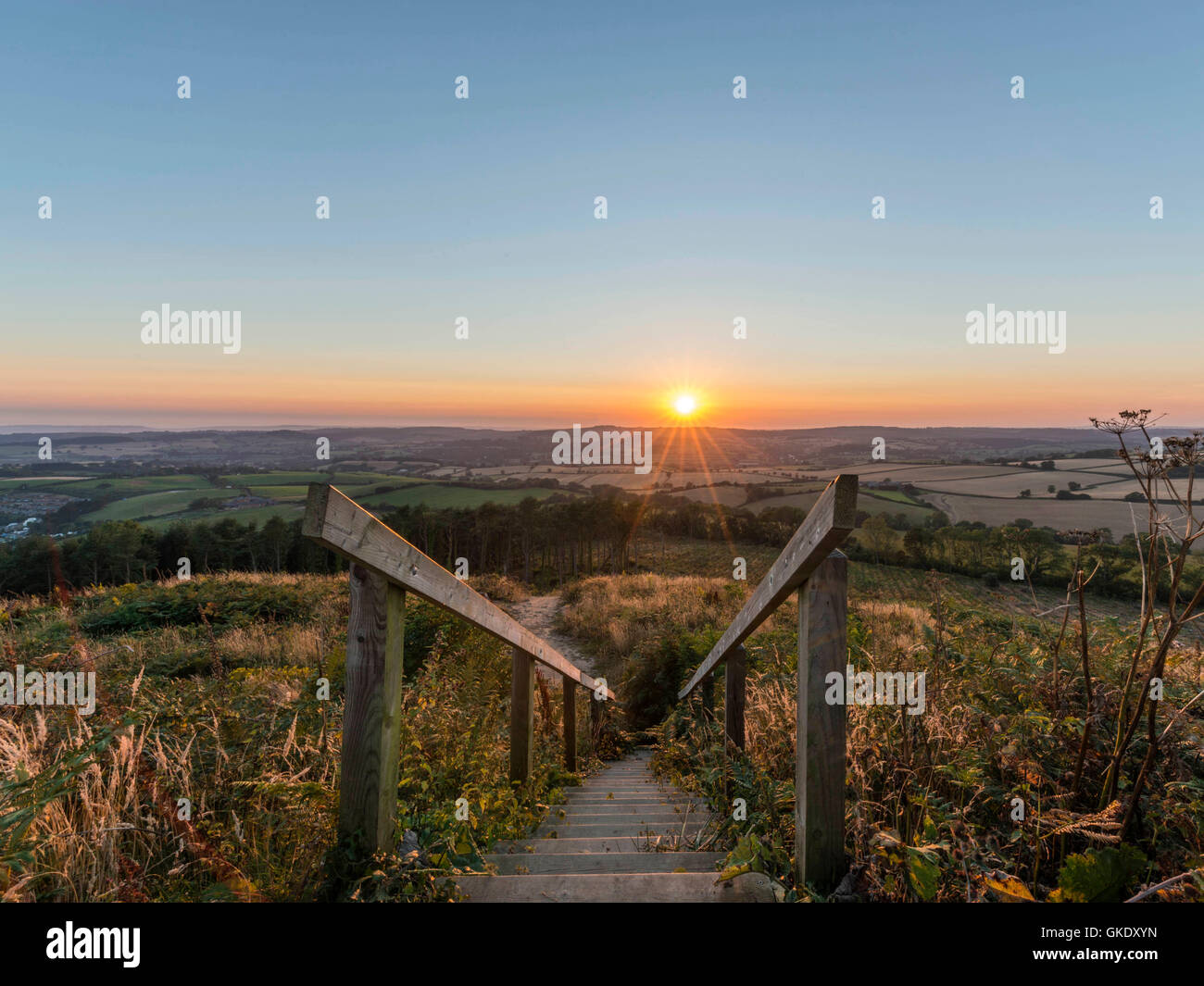 Paisaje representando la puesta del sol sobre la campiña de Devon. Imagen tomada en punto alto escalera de madera plataforma de visualización, Ladram Bay Foto de stock