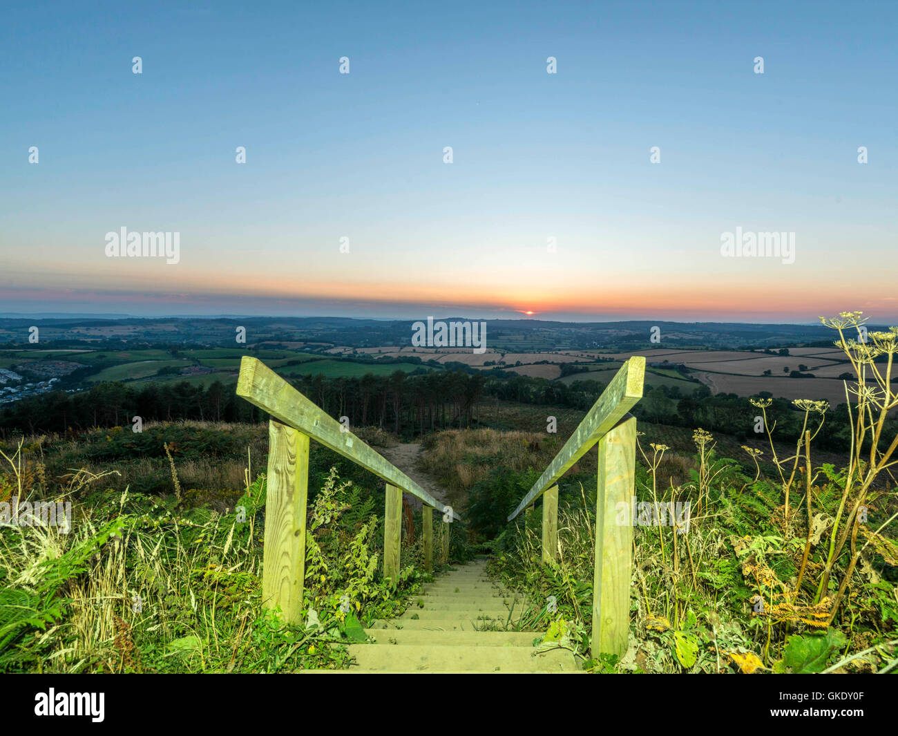 Paisaje representando la puesta del sol sobre la campiña de Devon. Imagen tomada en punto alto escalera de madera plataforma de visualización, Ladram Bay Foto de stock