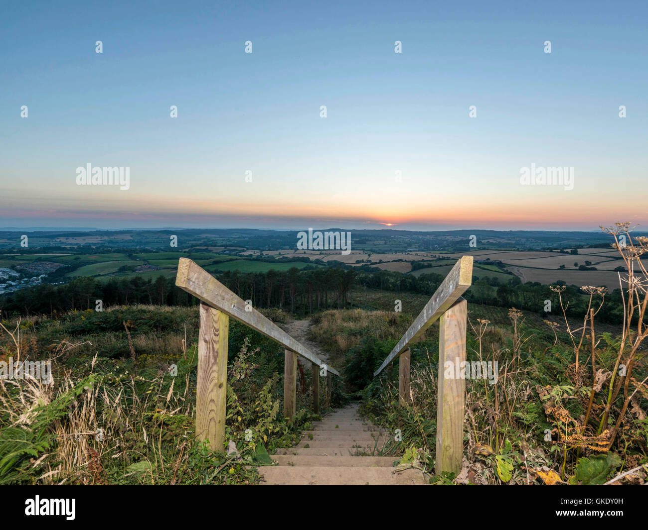 Paisaje representando la puesta del sol sobre la campiña de Devon. Imagen tomada en punto alto escalera de madera plataforma de visualización, Ladram Bay Foto de stock