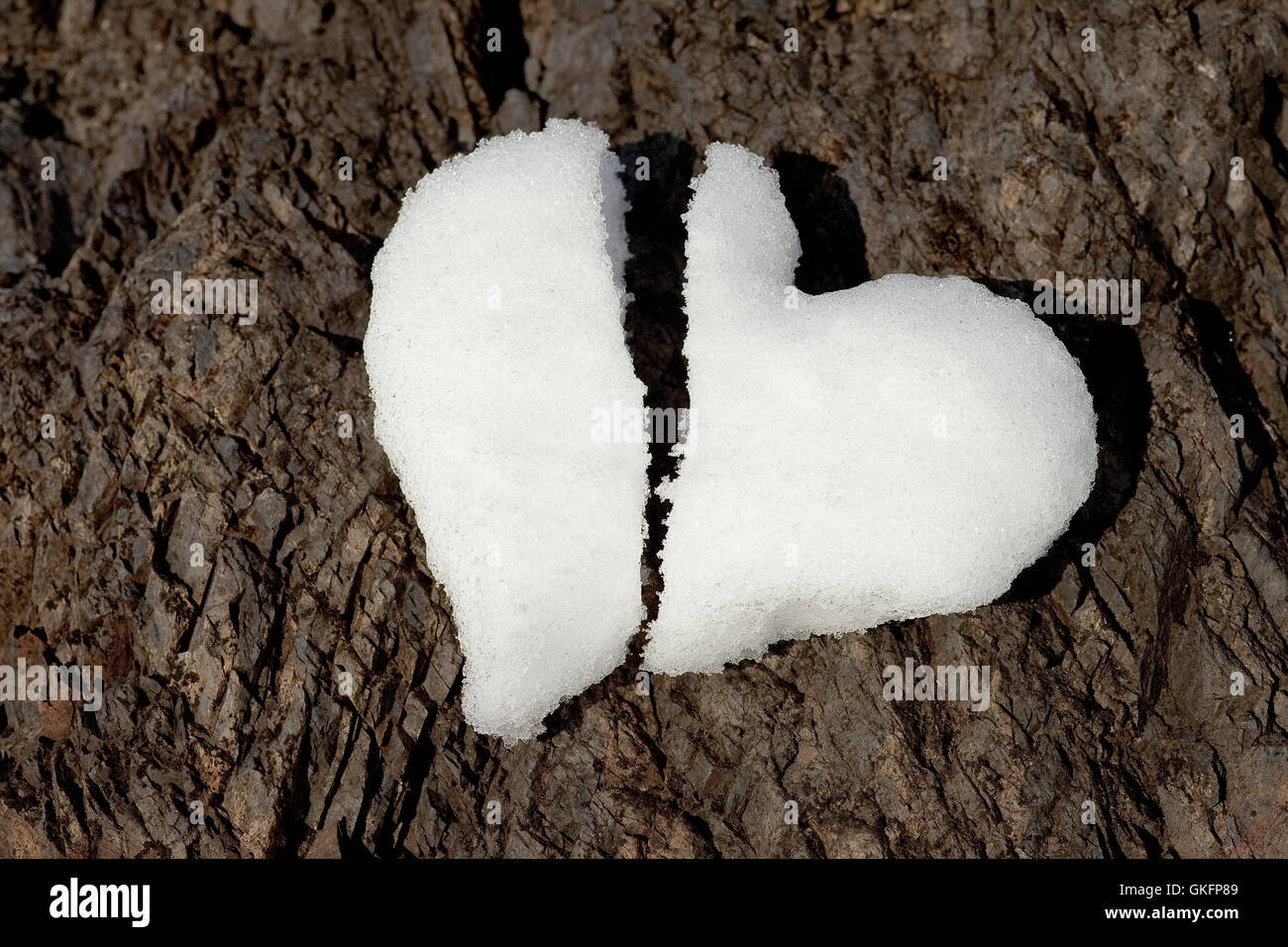 Corazón roto hechas de nieve sobre roca Foto de stock