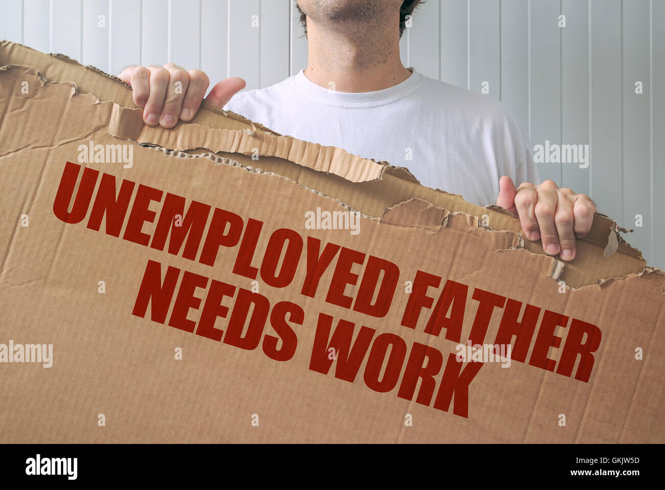 Desempleados padre necesita trabajar, hombre sujetando el banner con la búsqueda de empleo título Foto de stock