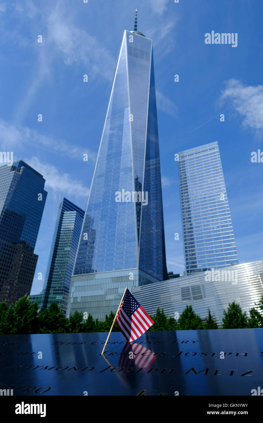 Torre de la libertad, One World Trade Center en Nueva York, Manhattan, Nueva York. Visto desde abajo con una bandera americana en primer plano en el 9/11 memorial. 09/08/2016 Foto de stock