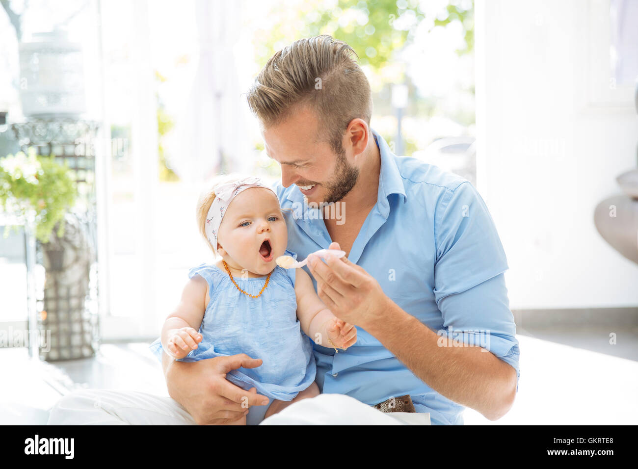 Alimentando a su bebé niña de papá Foto de stock