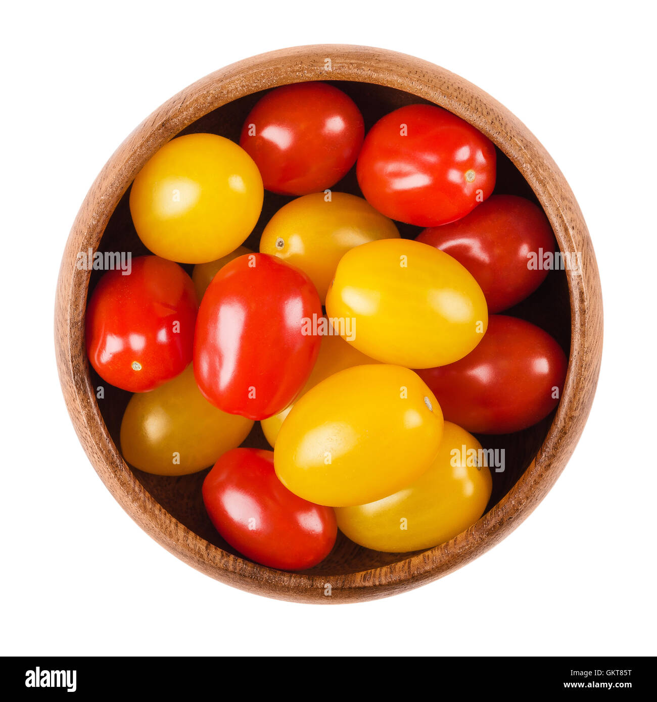 Cóctel en un recipiente de madera fondo Amarillo y rojo frutas maduras de Solanum lycopersicum, un tipo de baya fruto Fotografía de stock - Alamy