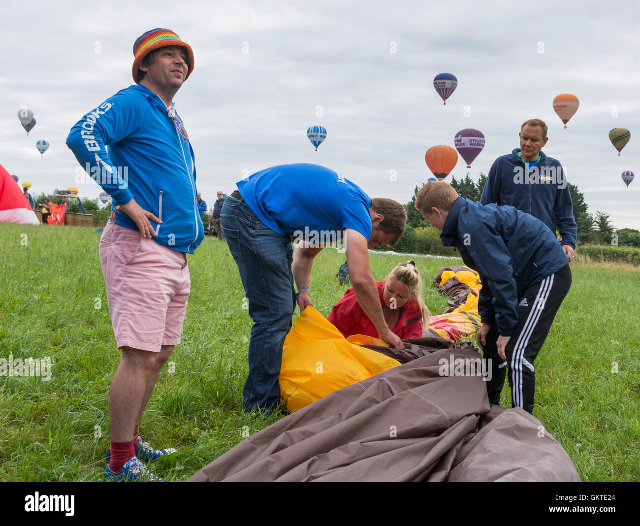 El piloto y su tripulación pack su globo en un campo en la 38ª anual de Bristol International Balloon Fiesta Foto de stock