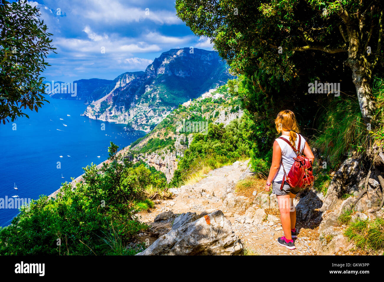 Excursionista hembra admira las vistas de la costa de Amalfi mientras camina por el sendero de los dioses Foto de stock