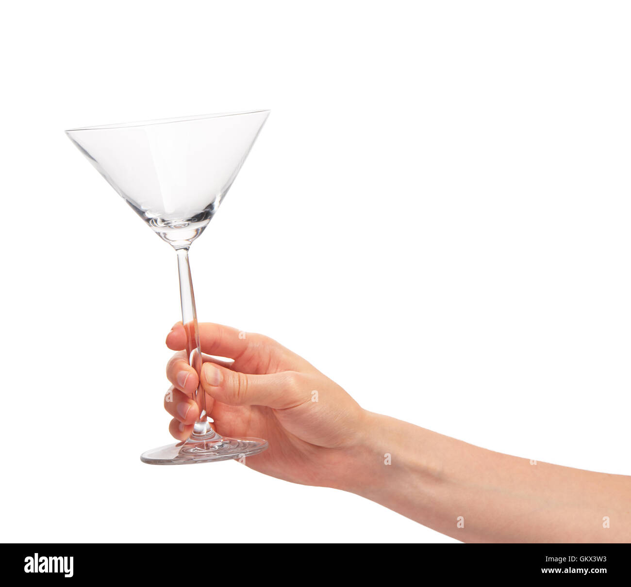 Cerca de mano femenina sosteniendo vacía copa de martini transparente limpio contra el fondo blanco. Foto de stock