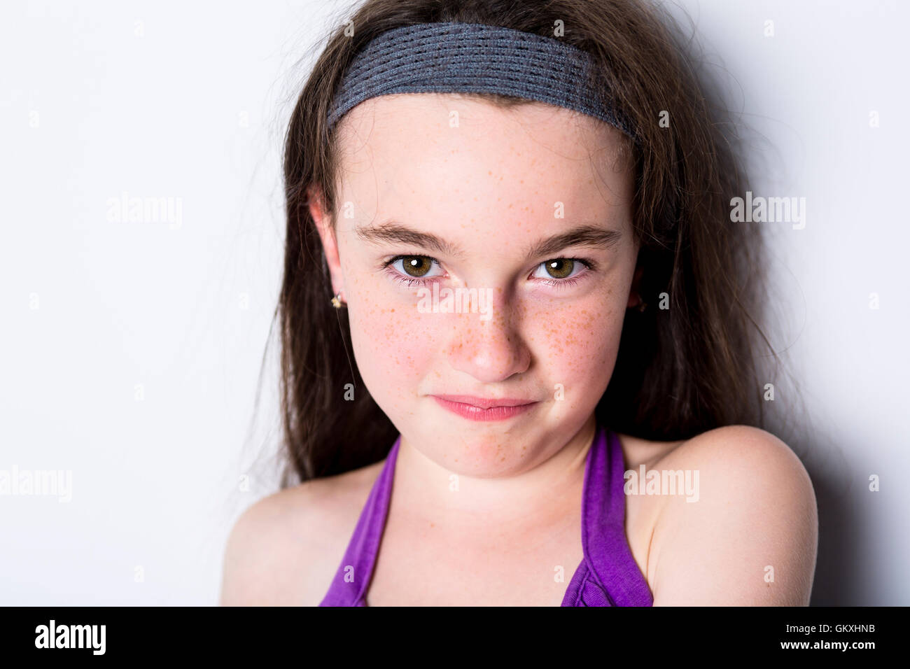 Retrato de niña de 10 años con rostro serio sobre un fondo blanco. Toma con  luz natural que entra a través de una ventana Fotografía de stock - Alamy