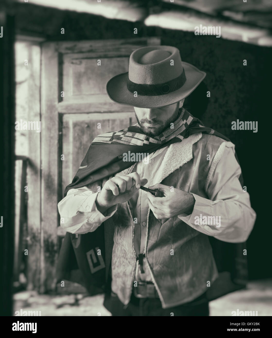 Pistolero del salvaje oeste mientras se desplaza por el tabaco. Imagen en blanco y negro. Foto de stock