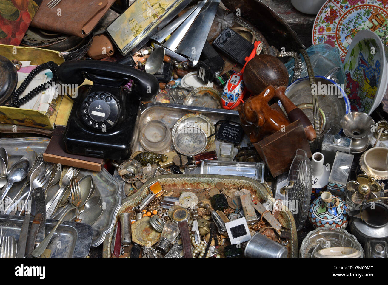 Objetos antiguos a la venta en mercado de pulgas. Antiguo teléfono dial  giratorio rusty cubiertos platos de porcelana vintage y otras cosas  polvorientas Fotografía de stock - Alamy